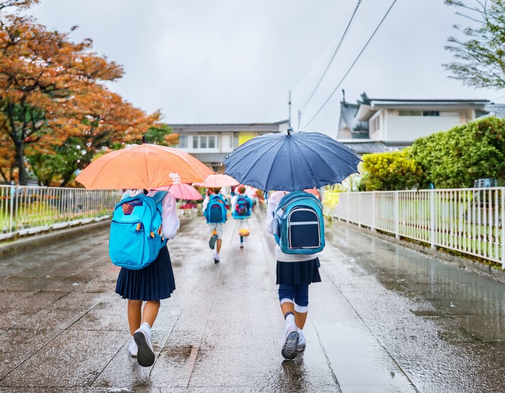 傘を挿して登校する小学生 傘を挿して登校する小学生